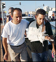 An injured man is helped away from the scene.