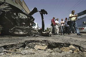 People gather at the site where a rocket fired by Palestinians from Gaza killed a woman in Sderot. (AP)
